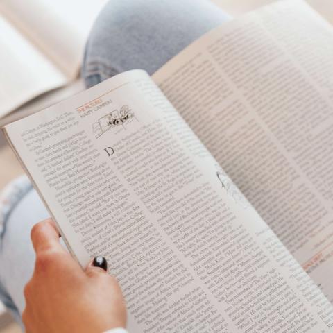 Image of a person holding an open magazine in their lap - Karolina Grabowska, Pexels